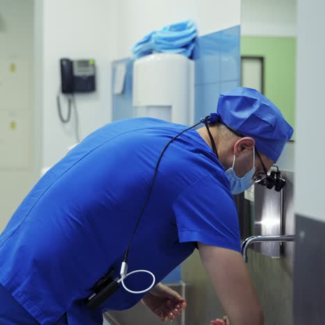 doctor washes his hands with soap and running water. correct way to wash hands according to the world health organization. male surgeon disinfects hands before surgery.