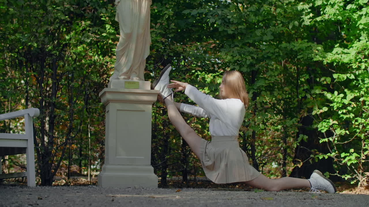 Woman stretching in park near statue