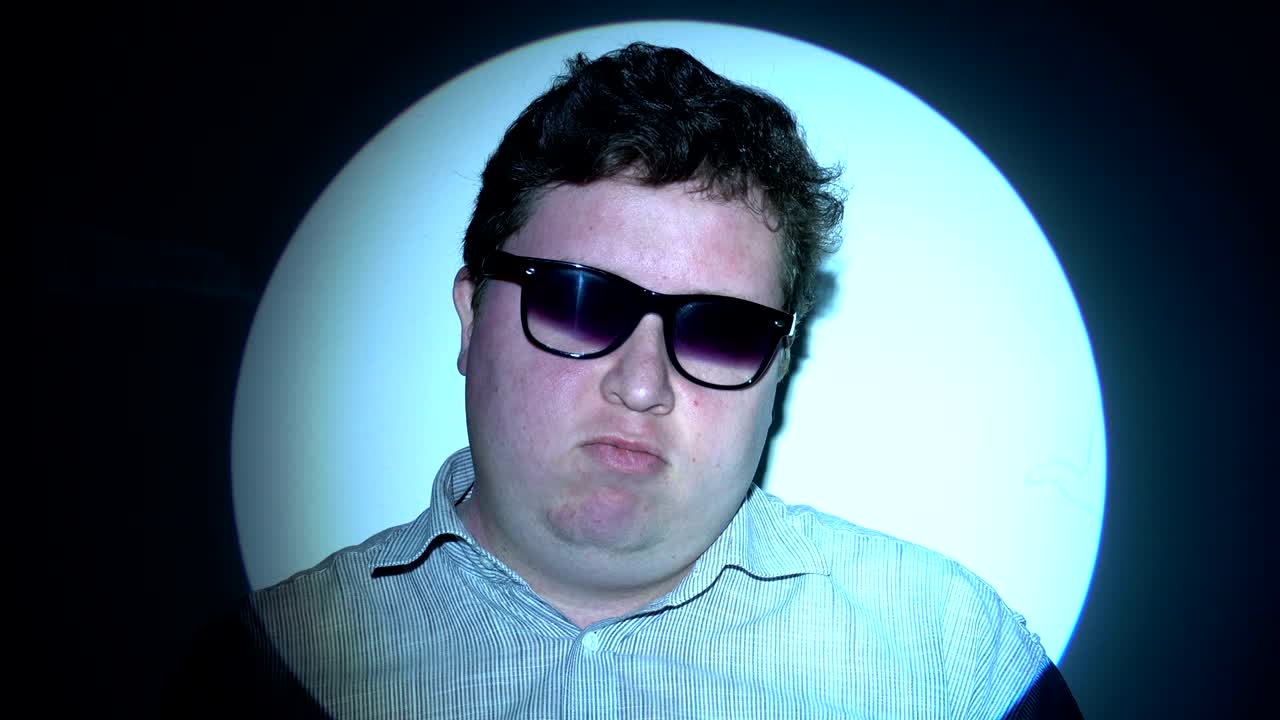 retrato de un hombre gordo en un haz de luz multicolor.