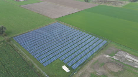 High-angle-of-small-solar-panel-park-surrounded-by-meadows