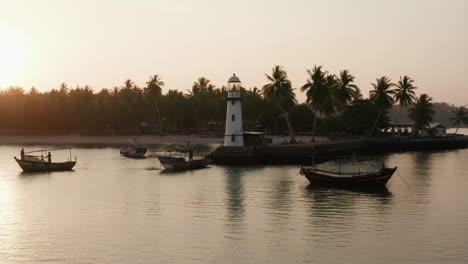 tropical lighthouse and boats at sunrise or sunset