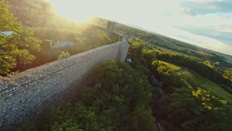 vuelo rápido sobre la comuna de monteriggioni al atardecer, provincia de siena, italia