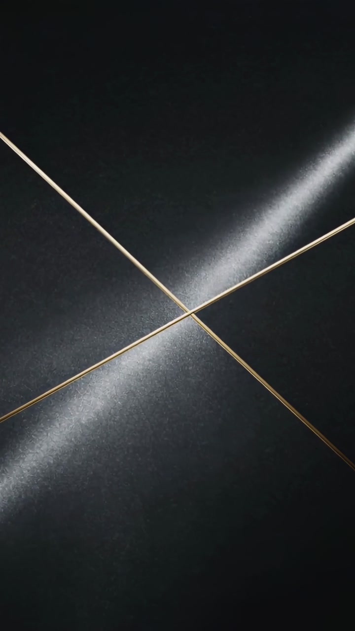 Vertical video: Moving light sweeping highlight across dark panel in studio revealing gold X seam