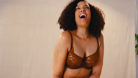 retrato de estudio de una mujer natural sonriente y segura en ropa interior que promueve la positividad corporal