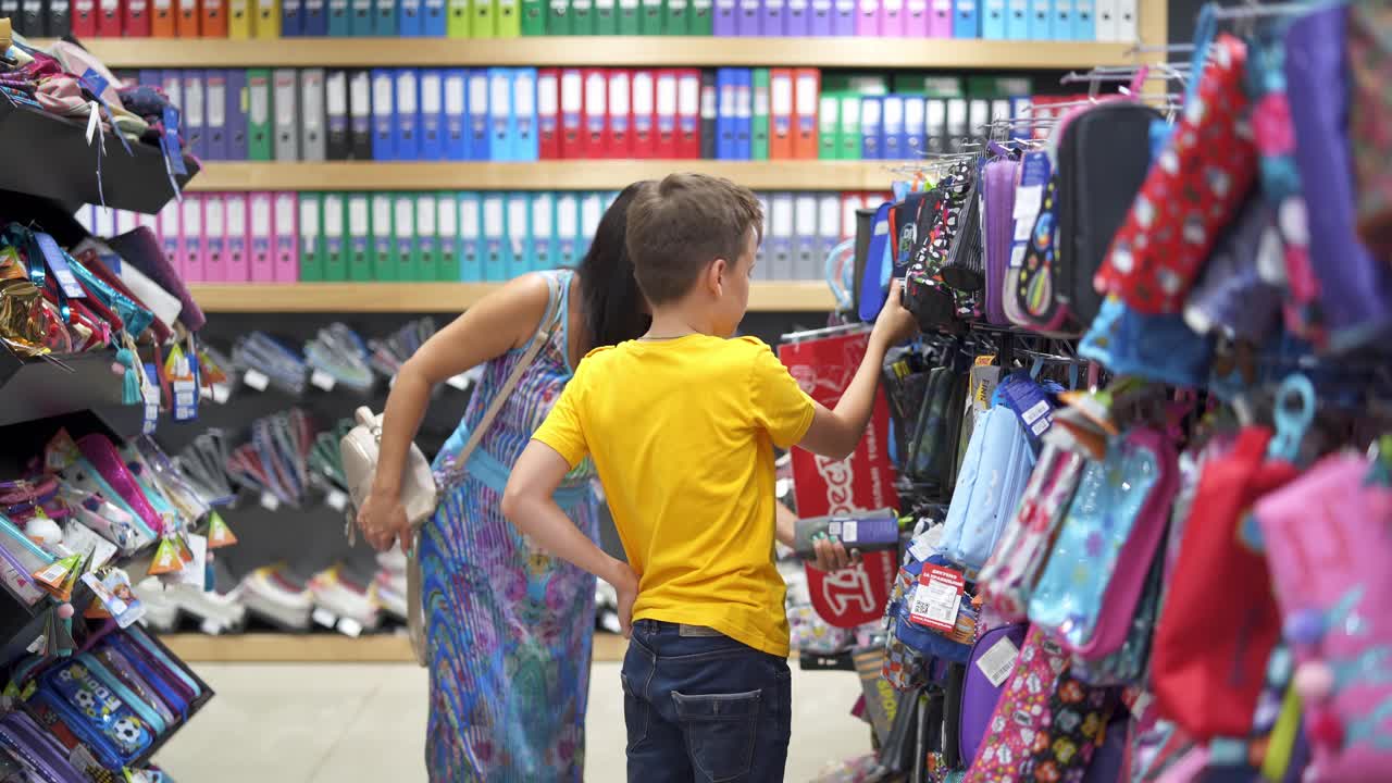 Boy choosing stationery for school. Cute child choosing school stationery in store
