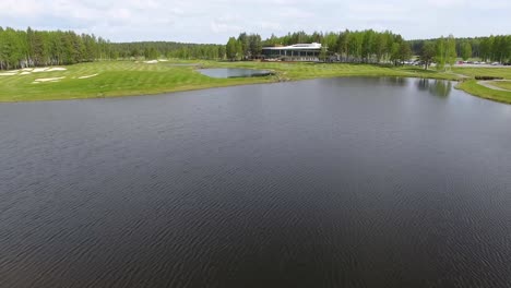 aerial view of a golf course with clubhouse and water features