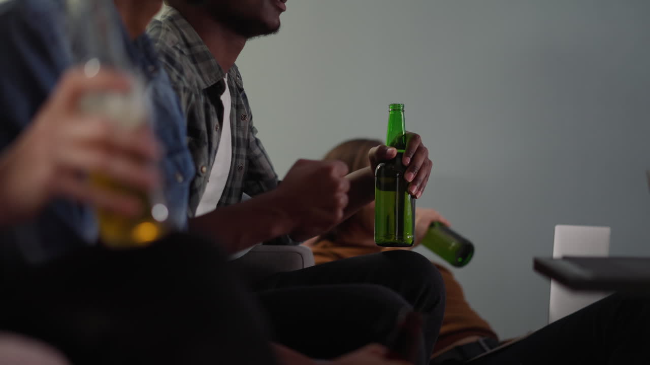 grupo de amigos bebe cerveza y disfruta de juegos deportivos a través de la televisión