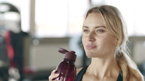 Durstige-Frau,-Die-Nach-Dem-Fitnesstraining-Im-Fitnessstudio-Wasser-Genießt.