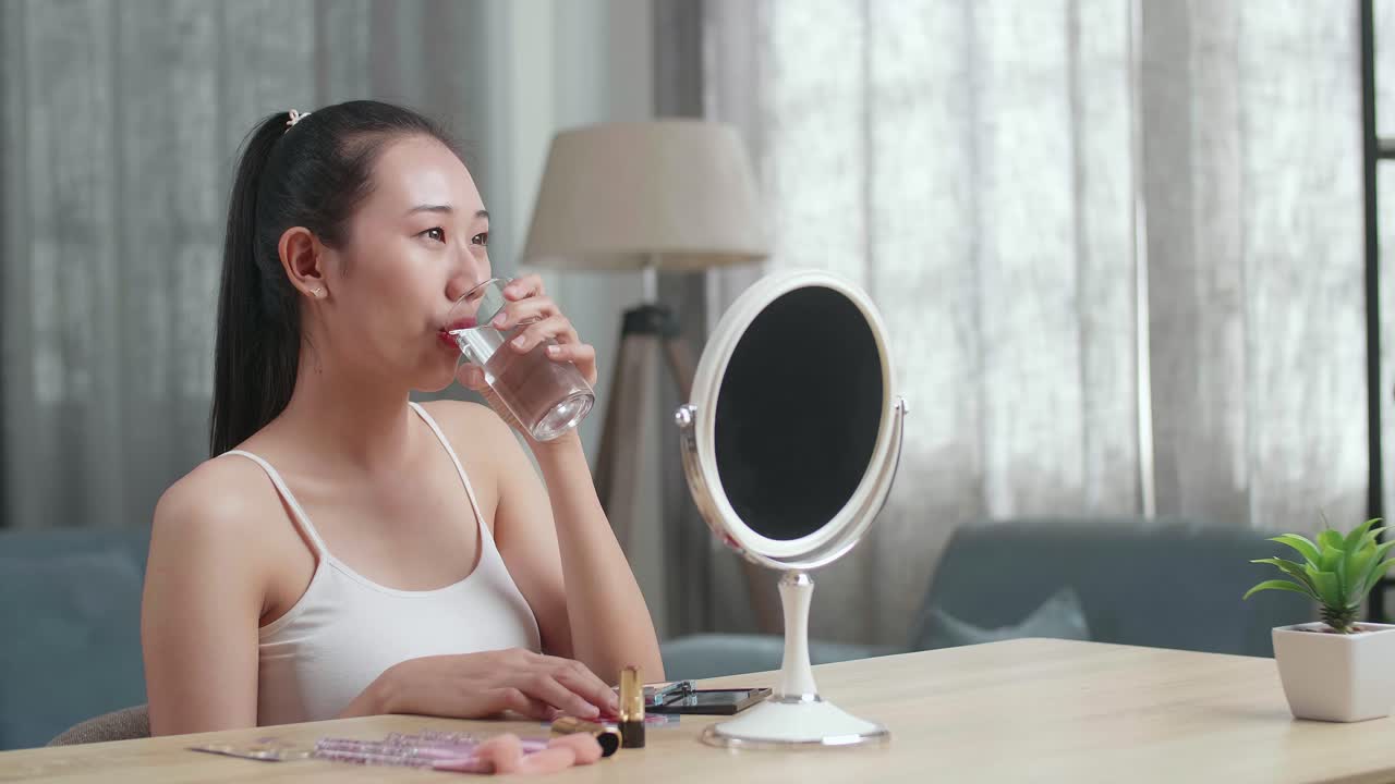 물을 마시고 메이크업을 하는 여자