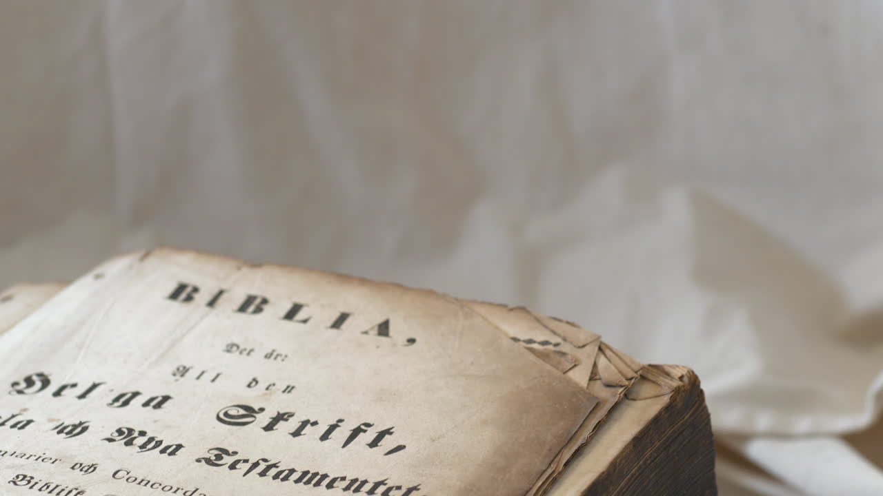Inclinazione verso l'alto di un'antica Bibbia in svedese con pagine marroncine e sgualcite