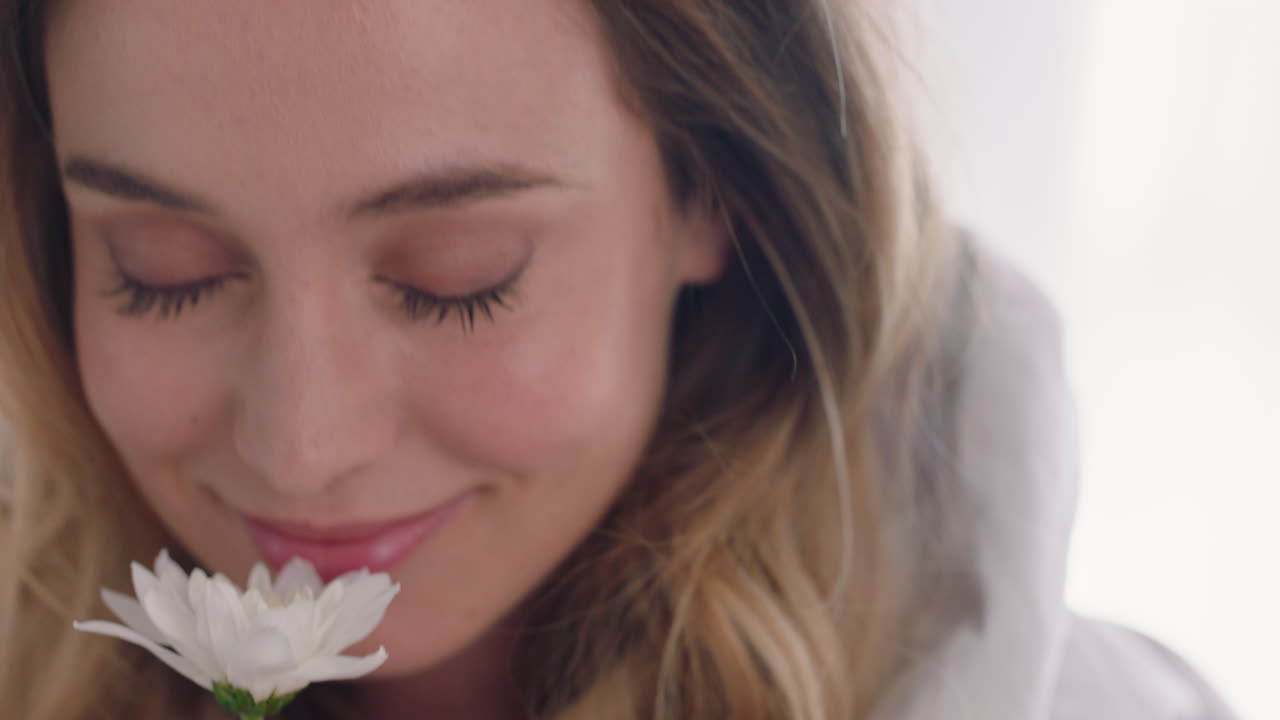 hermosa mujer joven que huele a flor disfrutando de la fragancia natural