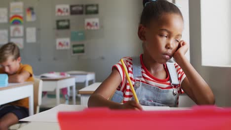 Video-Eines-Nachdenklichen-Afroamerikanischen-Mädchens,-Das-Im-Klassenzimmer-Am-Schreibtisch-Sitzt