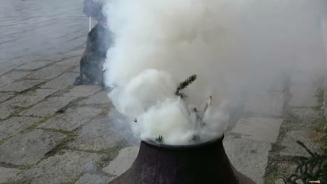 기도하는 동안 사원 앞의 도자기 또는 점토 꽃병 안에 나무를 태우는 티베트 마을 또는 사람들