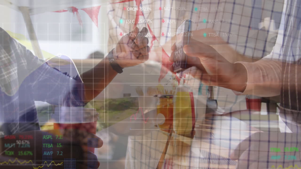 Two colleagues standing by cafe window holding coffee cup and smartphone while showing stock charts