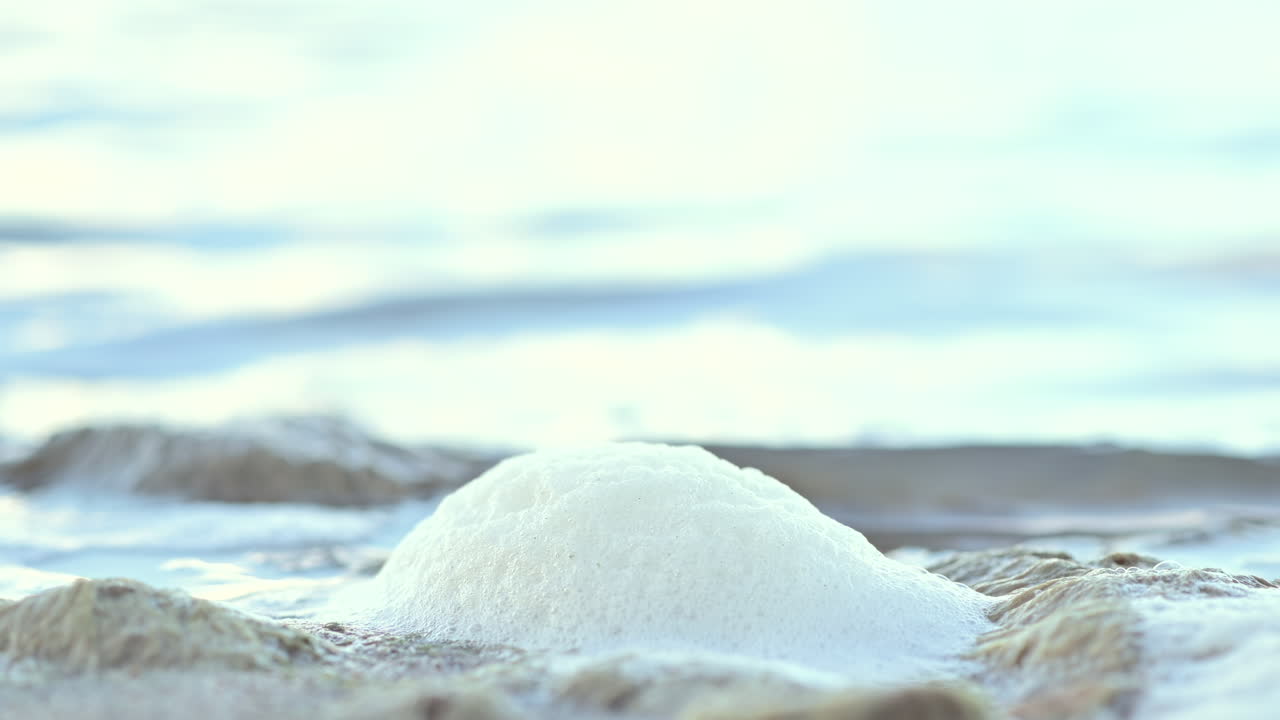 Close up of sea foam forming on coastal rocks as the waves crash