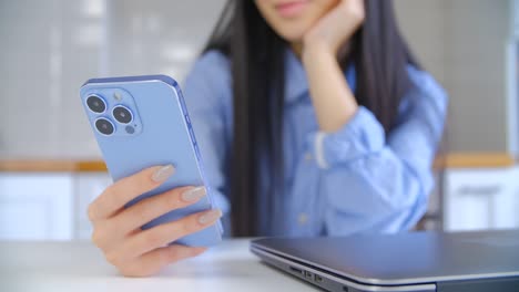 young woman using modern mobile phone. asian girl browsing social media app on smartphone device with triple camera. female use internet technology for communication and shopping online on lockdown