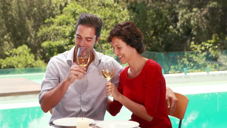 Pareja-Sonriente-Bebiendo-Vino-Junto-A-La-Piscina