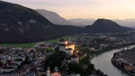 Imágenes-Aéreas-De-La-Ciudad-De-Montaña-Kufstein-Con-Fortaleza-En-La-Cima-De-La-Colina,-Paisaje-De-Verano-Al-Amanecer,-Posada-Del-Río-Serpenteando-Por-El-Valle---Alpes-Austriacos-Desde-Arriba,-Tirol,-Austria,-Europa