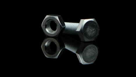 industrial bolt and nut on reflective black background