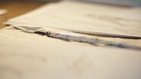 male hand picking up an ink pen, closeup