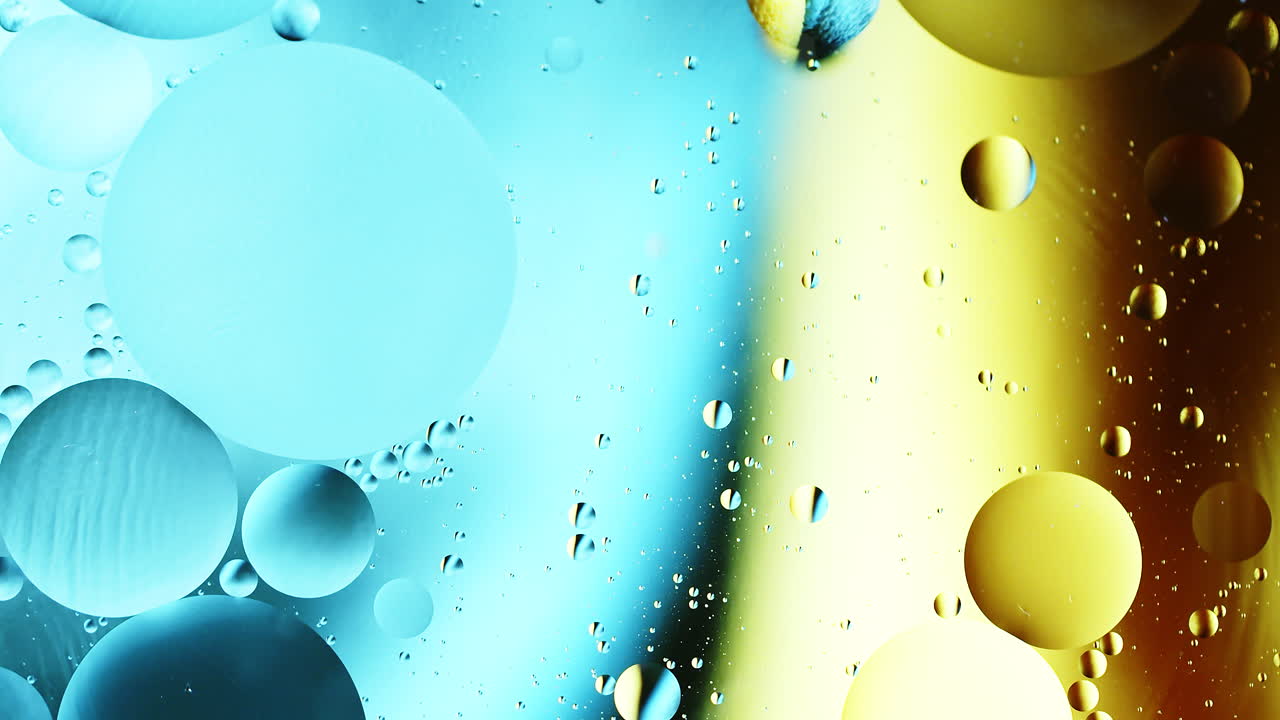 Real close up oil bubbles in water rotation with color gradient abstract mixing background