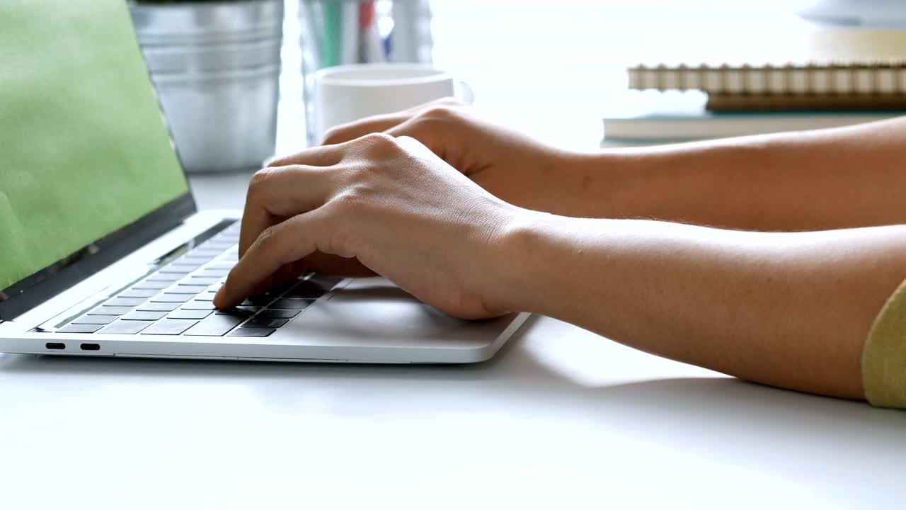 Close up hand typing on a Keyboard computer laptop at office. One young woman only using computer desktop PC.
