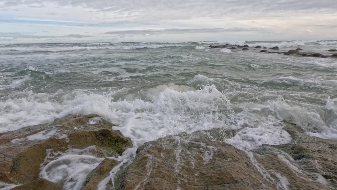 olas chocando contra las rocas en cámara lenta