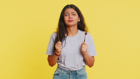 Hungry-woman-waiting-for-serving-dinner-meal-dishes-with-restlessness-holding-cutlery-fork-knife