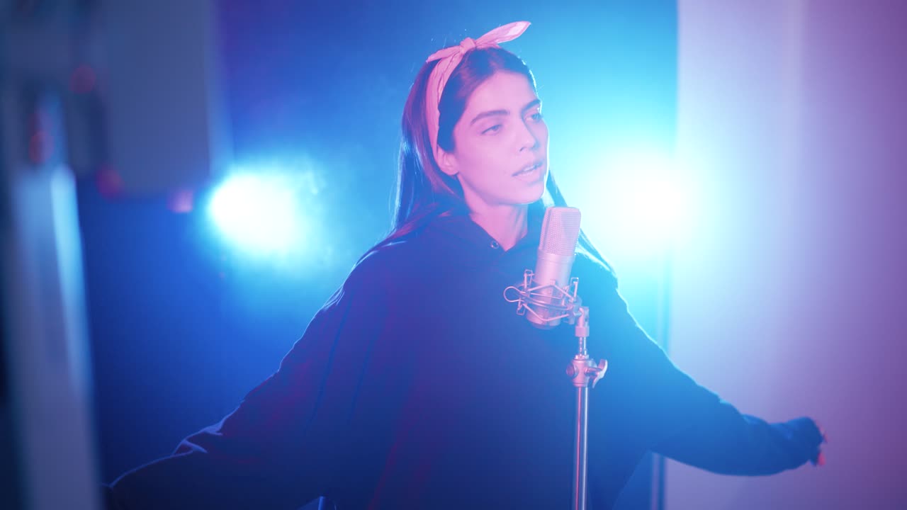 Nuori nainen laulaa popmusiikkia vanhaan mikrofoniin lavalla