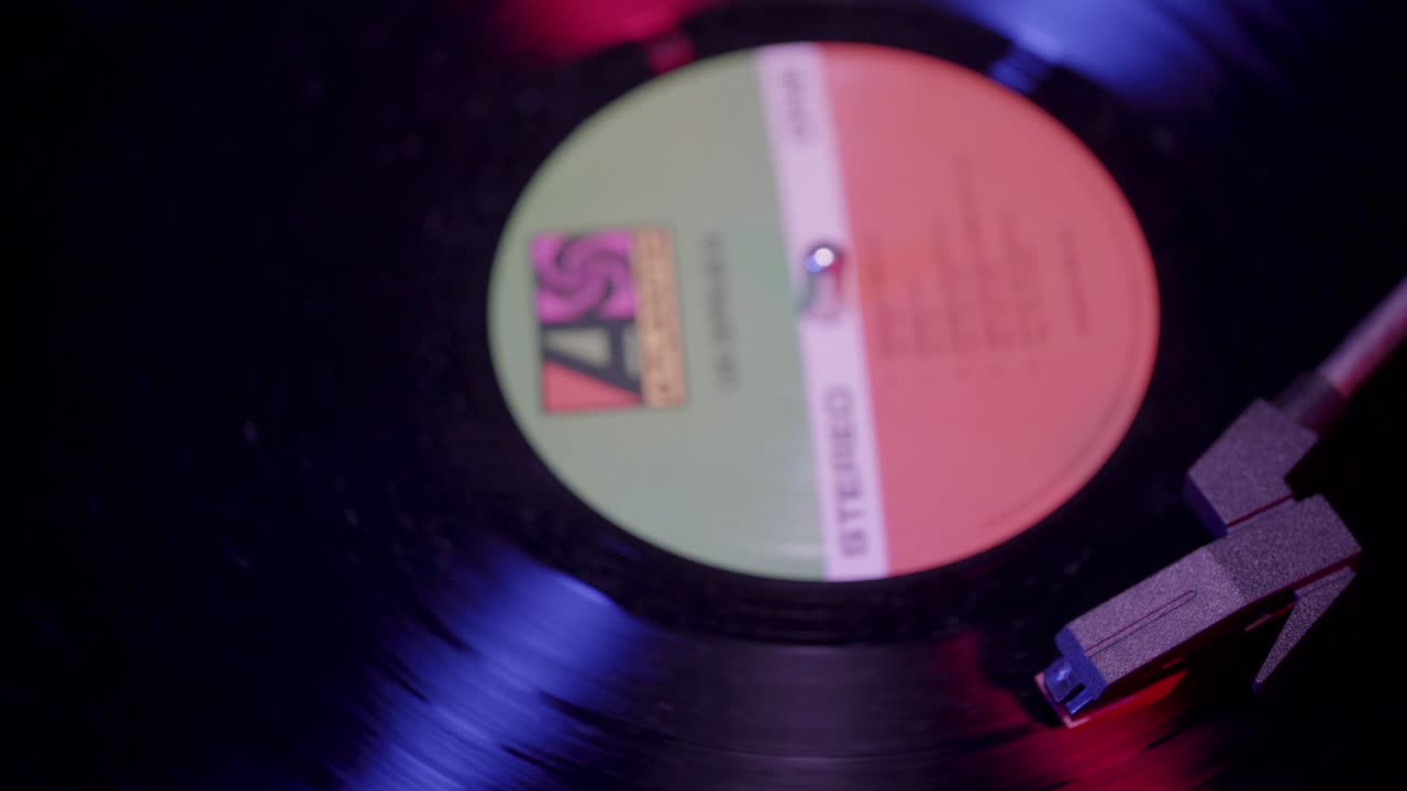 Close-up of Vinyl Record Spinning on Turntable with Colorful Lights