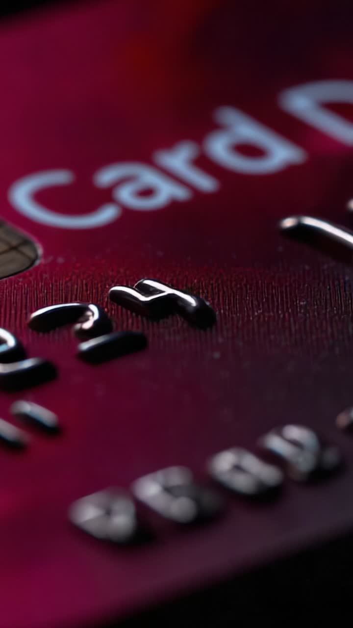 Close-up View of a Credit Card Showing Numbers and Logo, Highlighting the Material and Design Elements in a Vibrant Red Color Scheme