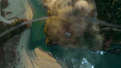 toma de drones de la famosa carretera de la costa pacífica de california cruzando playas y ríos en el resplandor de la mañana