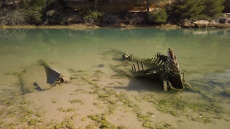 reveal pan right of sunken skeleton boat abandoned near sea in spain