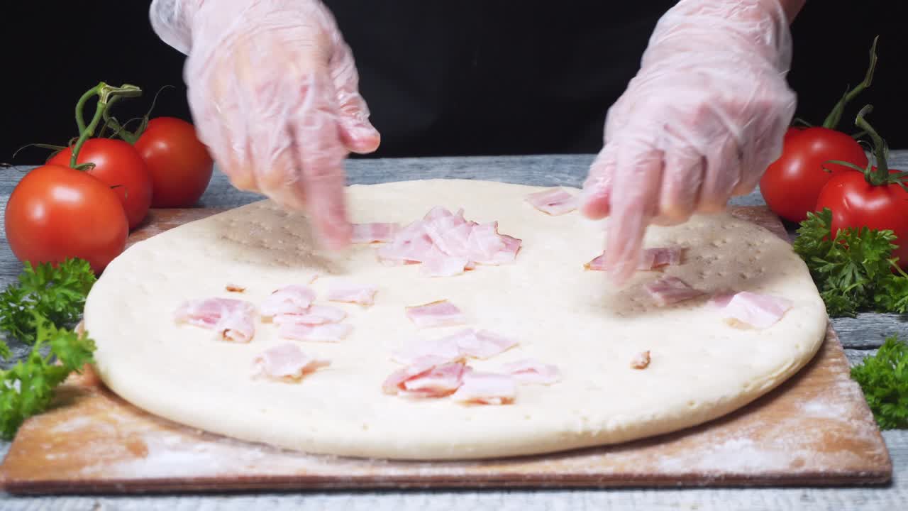 Chef making pizza with bacon topping