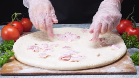 chef haciendo pizza con tocado de tocino