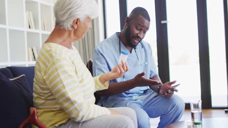 video of african american male doctor giving medicines to caucasian senior woman
