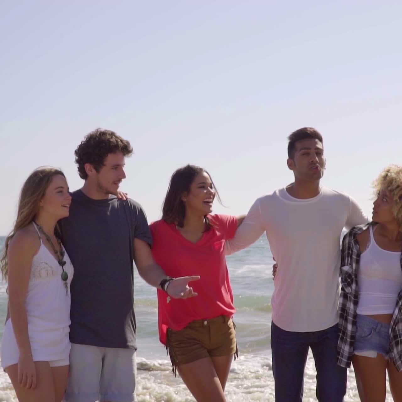 Gruppo multirazziale di giovani amici sulla spiaggia