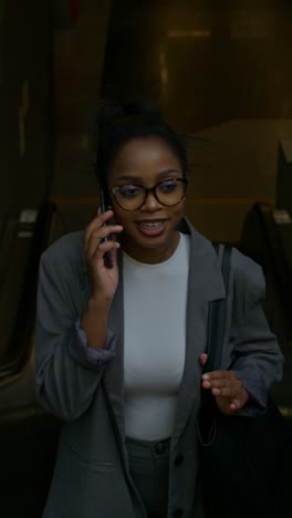 woman talking on phone on escalator