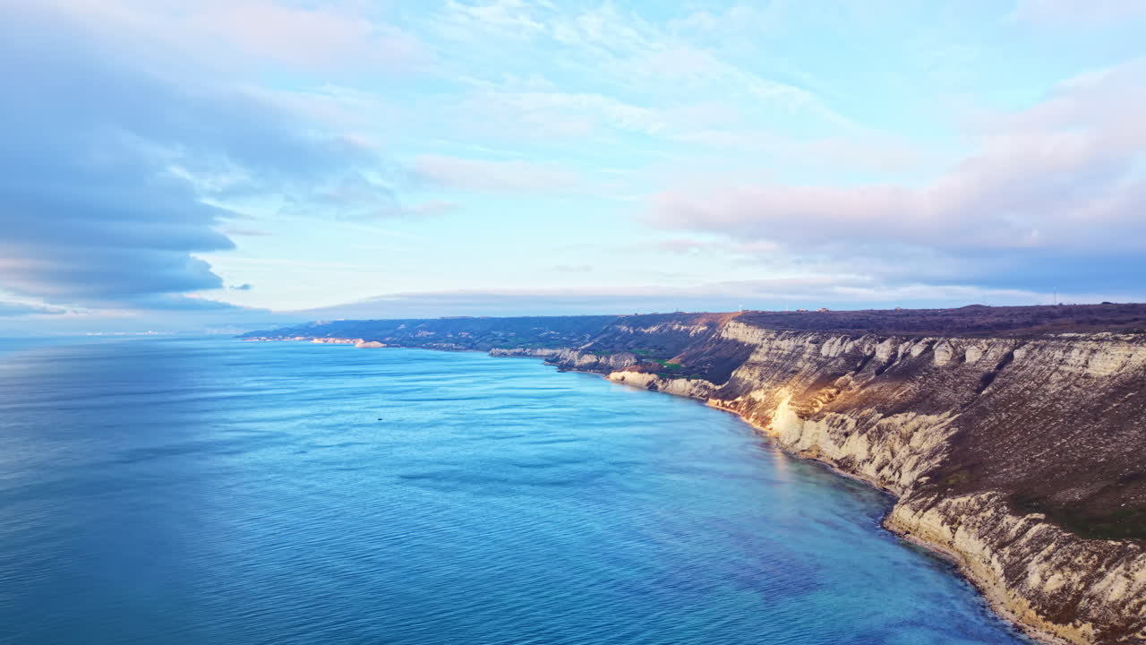 Costa vicino all'acqua con scogliere e mare calmo alla luce del giorno