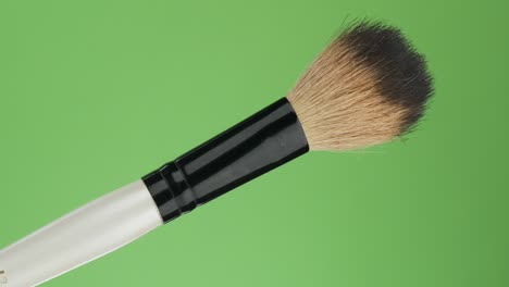 diagonal rotation of the makeup brush. isolated on green.