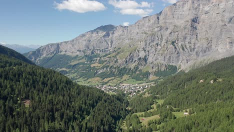 tilt up from distant town in valley to a blue sky and mountain summit in switzerland