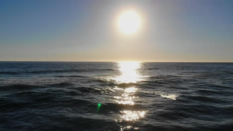 pull out from beautiful ocean sunset and waves to empty volleyball courts on huntington beach with aerial 4k drone