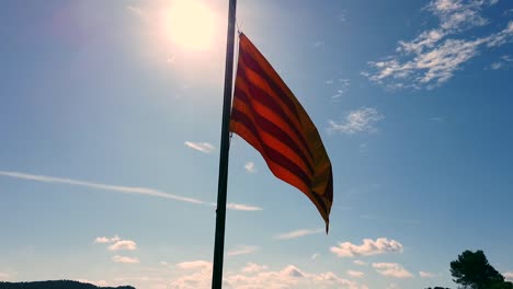 catalan flag in the sun with a blue sky and some clouds