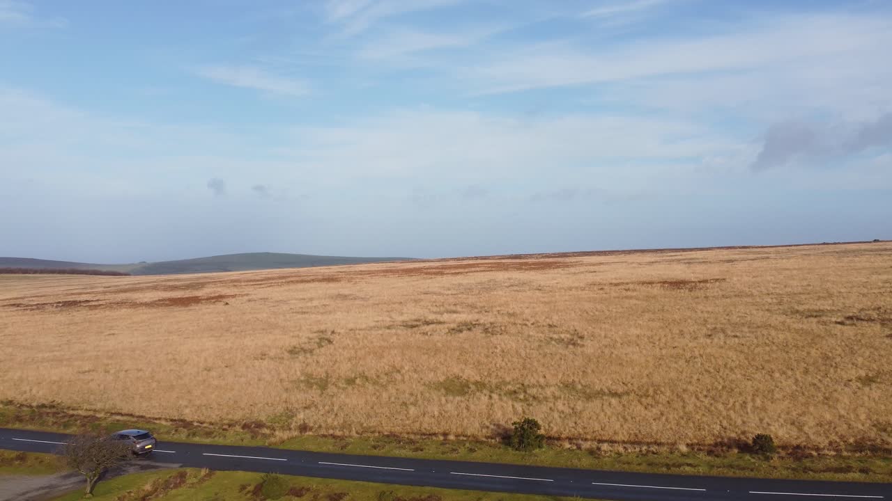 Stigende luftdrone over landevej afslører hedelandskab og bølgende opdyrkede marker i Exmoor UK 4K.