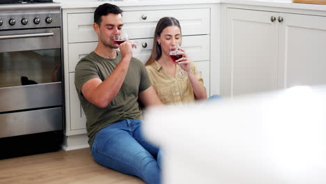 Happy-couple-on-floor-in-kitchen-with-wine