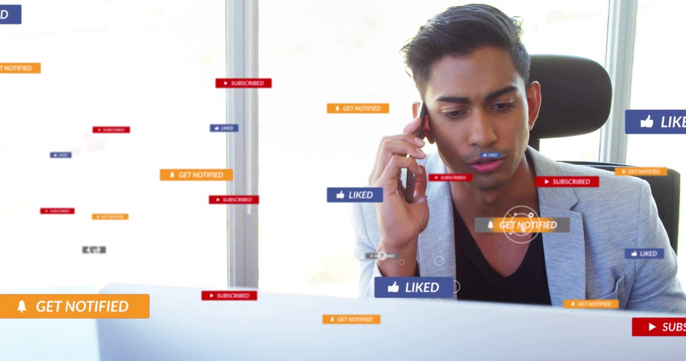 Office worker holding phone and monitoring laptop, new alerts increasing social media callouts