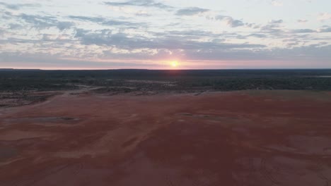 Clip-De-Drone-Que-Muestra-Un-Amanecer-Rosado-A-Través-De-Las-Nubes,-Sobre-Un-Colorido-Paisaje-Del-Interior-De-Australia