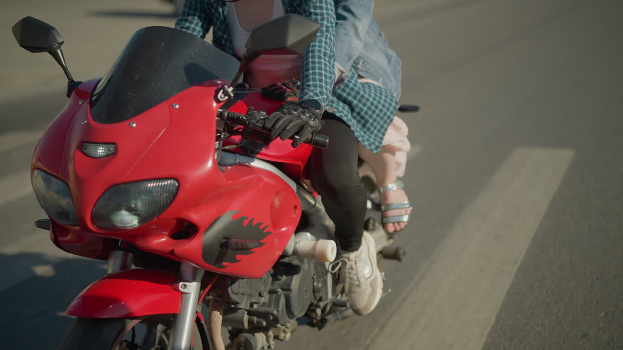 두 명의 여성이 도시 도로를 타고 전력 자전거를 타고 건물을 지나가고 다른 거리에서 나오는 차의 흐릿한 시야를 지나갑니다.