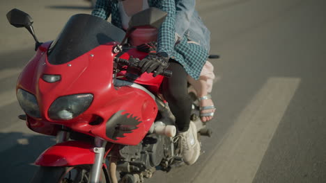 two ladies riding a power bike through an urban road, passing by buildings and a blur view of a car coming out of another street