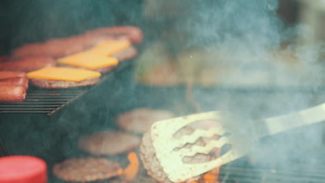 Flames-burst-from-moving-and-flipping-hamburgers-on-a-bbq-grill-outside-for-a-weekend-cookout